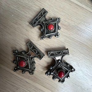 Metal pendants with small red stone.